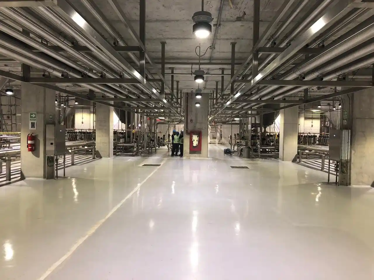 Interior de una planta industrial con sistemas de tuberías y conexiones complejas instaladas, mostrando el resultado final de una correcta ingeniería básica y de detalle en la construcción.